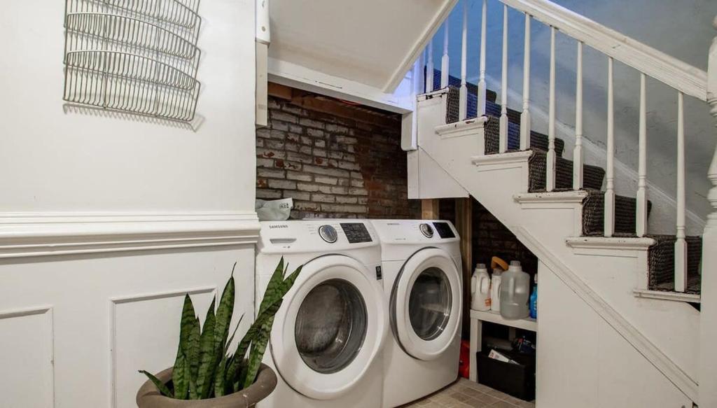 a washing machine in a laundry room with a staircase at DesignerFlat Nestled Between Dupont&Logan Circles in Washington, D.C.