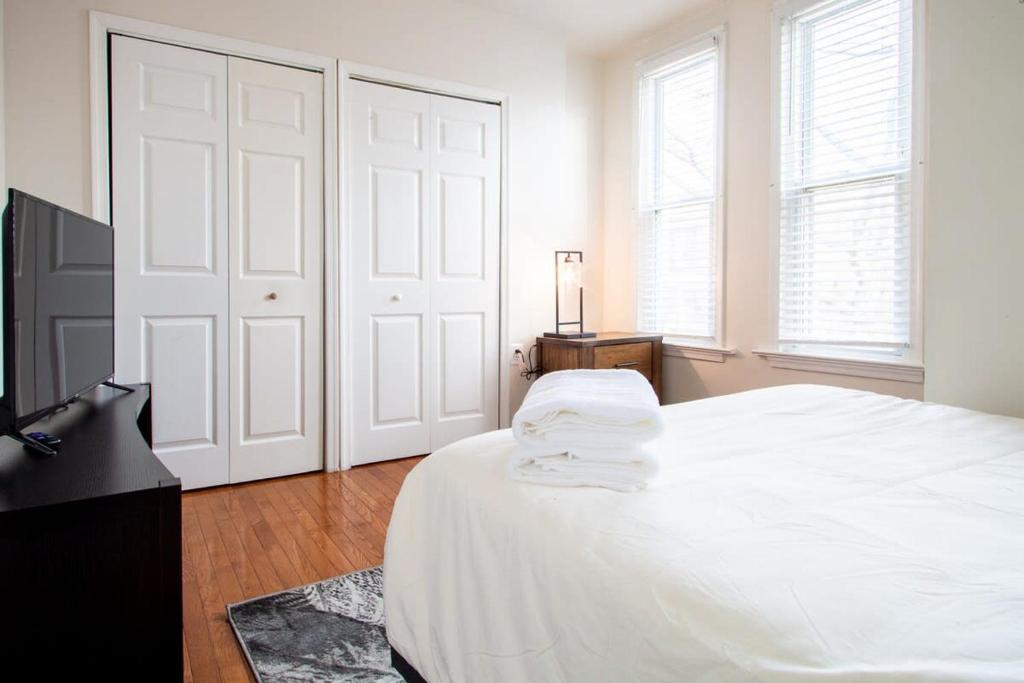 a white bedroom with a bed and a television at NoMA 3BR Townhome - UnionMarket H St Streetcar in Washington, D.C.