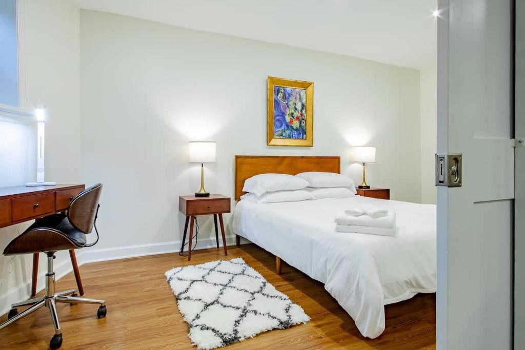 a bedroom with a white bed with a desk and a chair at A Classy Corner of DC Minutes walk to Dupont Circle in Washington, D.C.