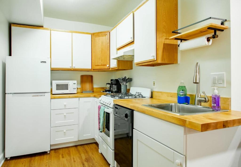 a kitchen with white cabinets and a sink at A Classy Corner of DC Minutes walk to Dupont Circle in Washington, D.C.