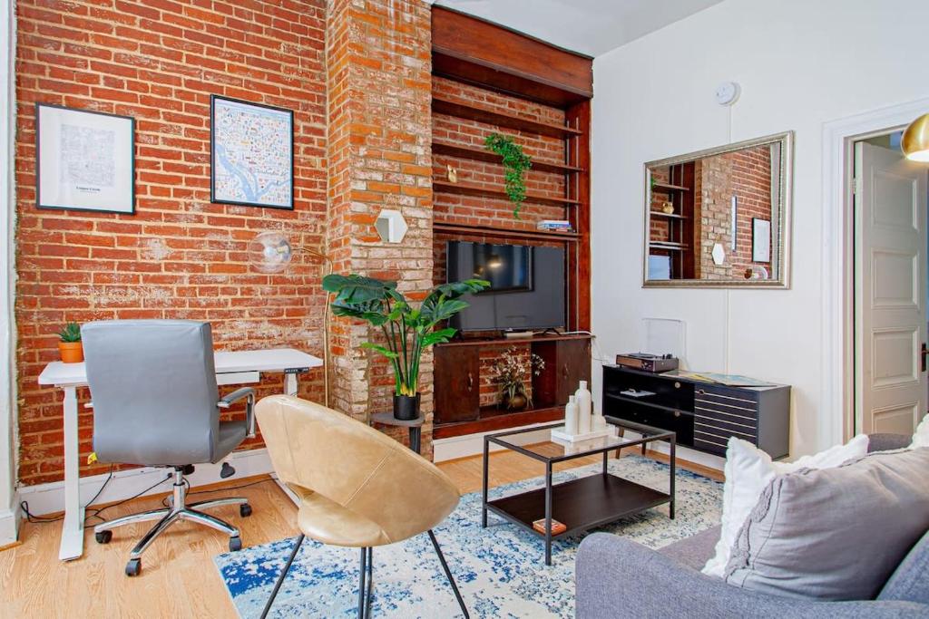 a living room with a brick wall at Classy 1-BR Flat Nestled Between Dupont & Logan in Washington, D.C.