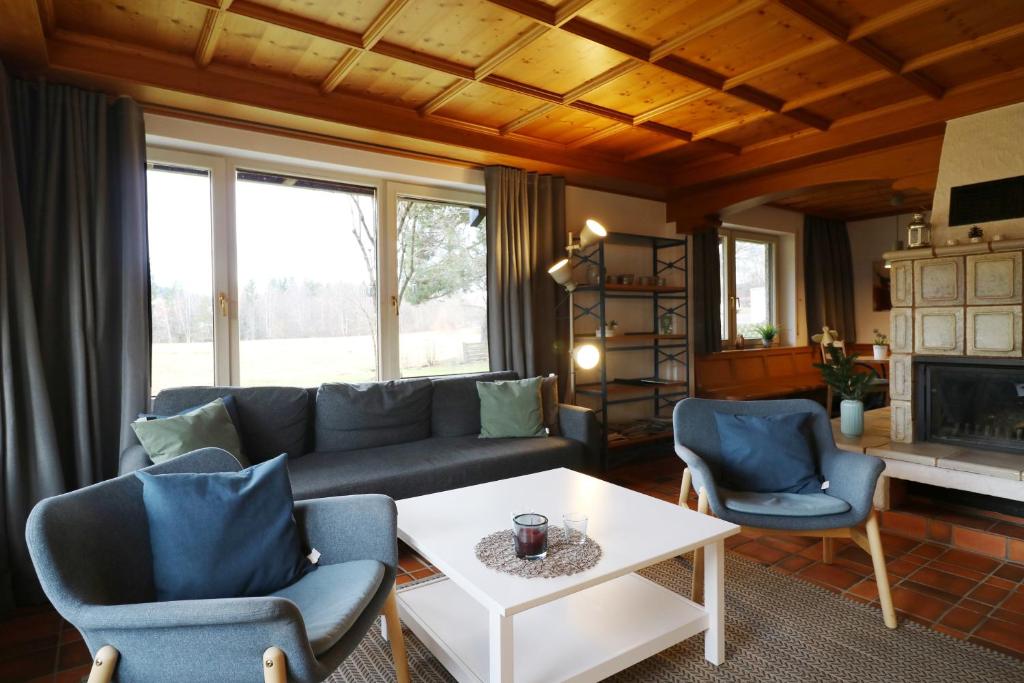 ein Wohnzimmer mit einem Sofa, Stühlen und einem Tisch in der Unterkunft Hus im Schwefelmättle, Hinterzarten in Hinterzarten