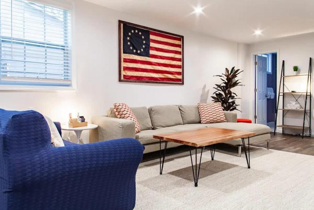 a living room with a couch and an american flag on the wall at Fantastic Falls Church HomeBase for DC area travel in Arlington