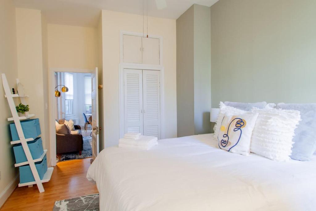a bedroom with a large white bed with white pillows at Classy 1-BR Flat Nestled Between Dupont & Logan in Washington, D.C.