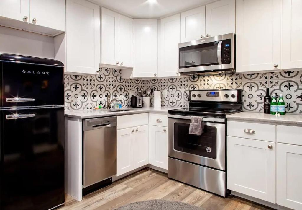 a kitchen with white cabinets and stainless steel appliances at Fantastic Falls Church HomeBase for DC area travel in Arlington