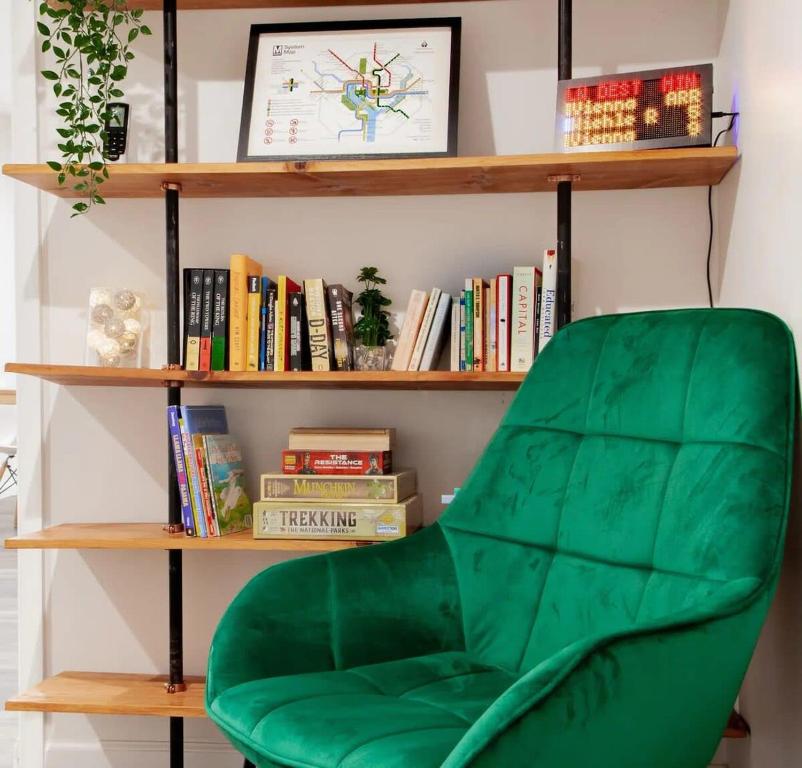 a green chair sitting in front of a book shelf at Fantastic Falls Church HomeBase for DC area travel in Arlington