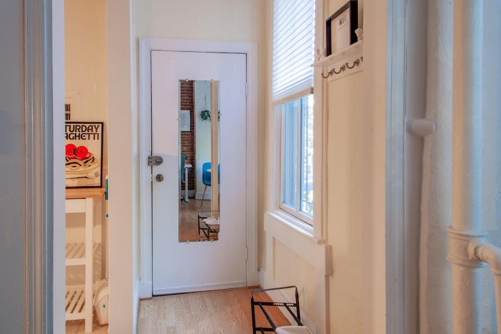 a hallway with a white door and a window at Classy 1-BR Flat Nestled Between Dupont & Logan in Washington, D.C.