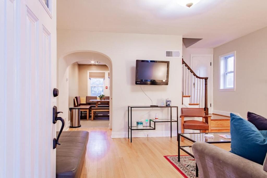 een woonkamer met een bank en een tv aan de muur bij Pentagon City Homestay Parking available in Arlington