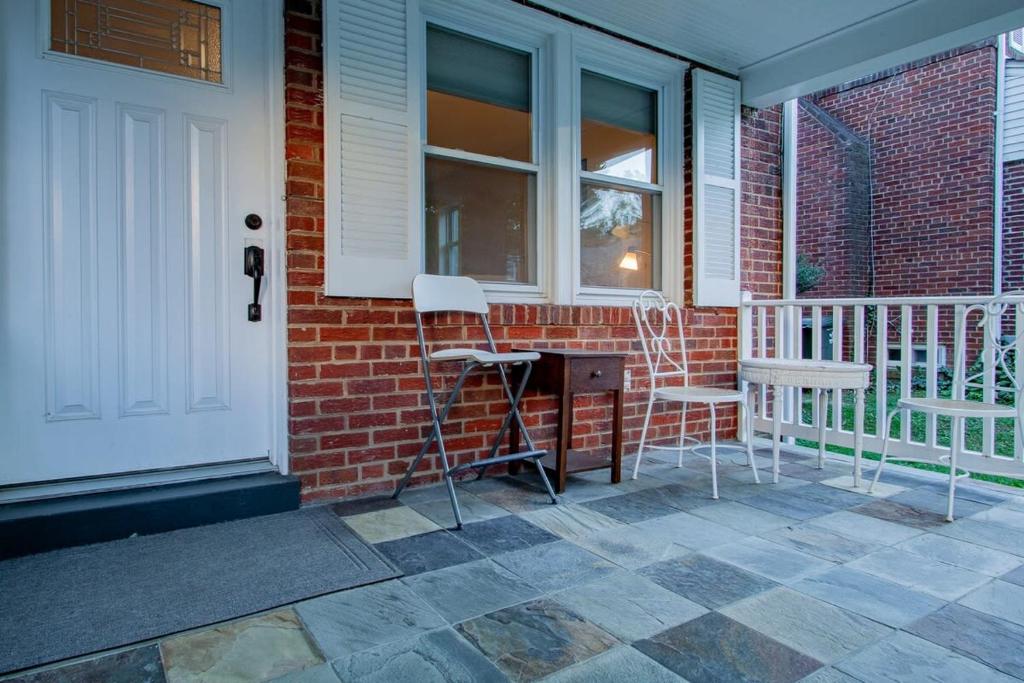 a porch with two chairs and a desk on a house at Pentagon City Homestay Parking available in Arlington