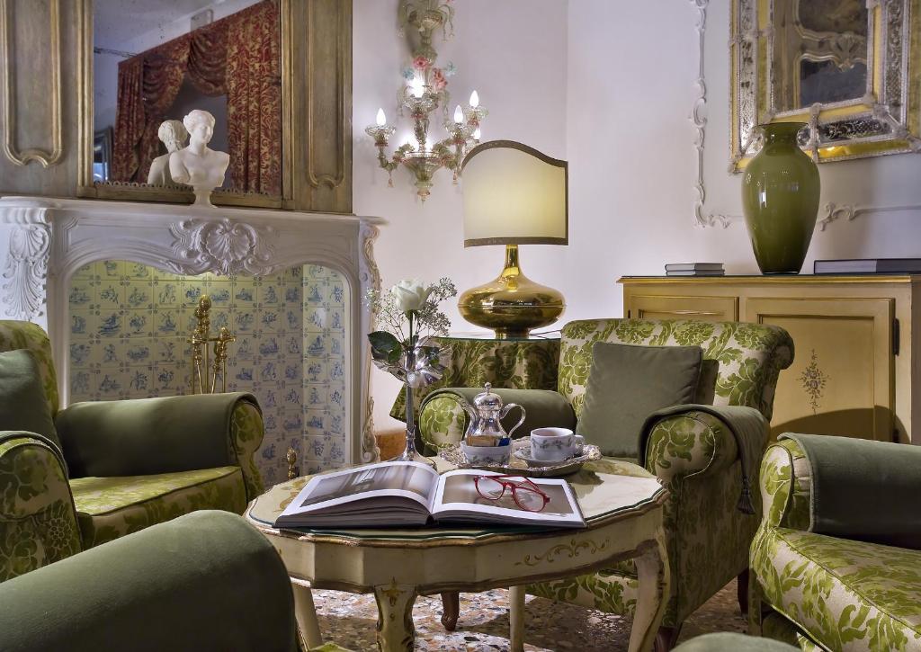 a living room with chairs and a table with a book at Hotel Giorgione in Venice