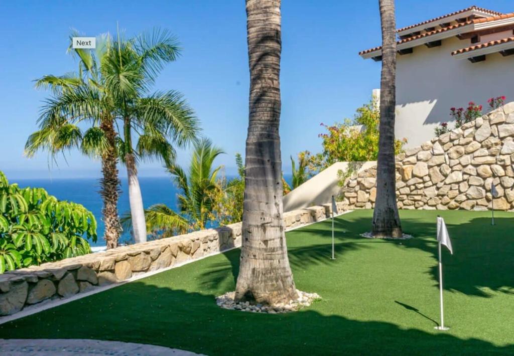 a golf course with palm trees and a resort at Infinite views of Palmilla beach and East Cape in San José del Cabo