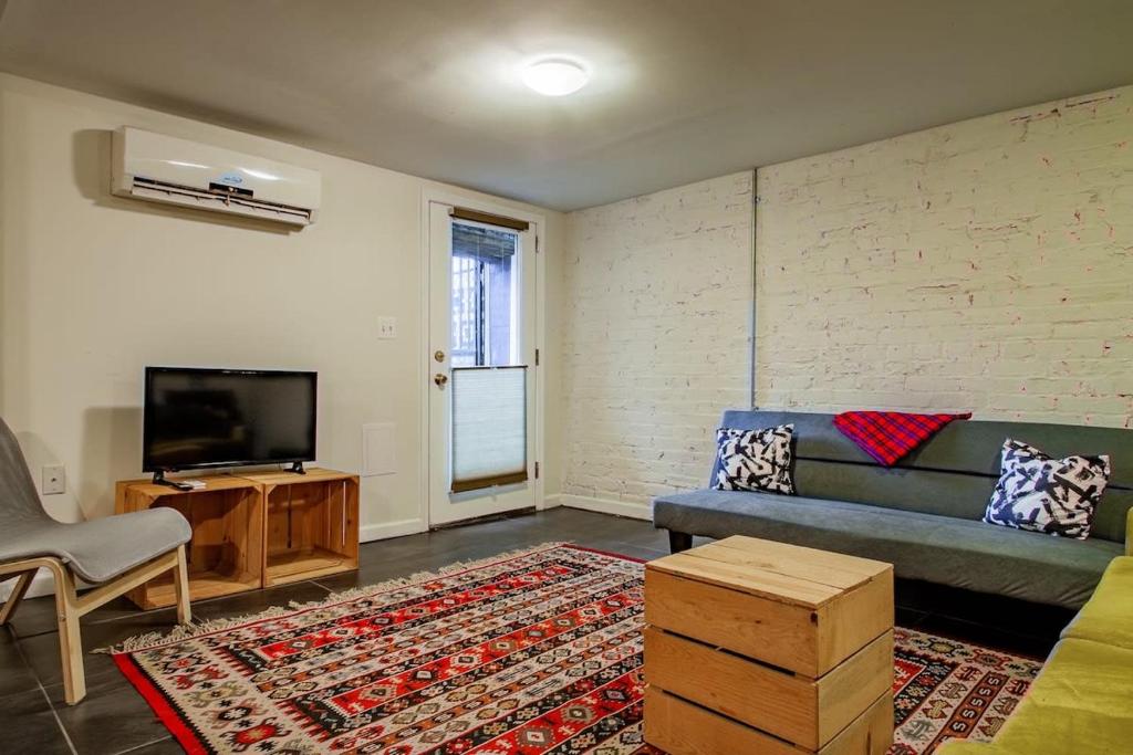 a living room with a couch and a flat screen tv at Rest Easy in this Bloomingdale English Basement in Washington, D.C.