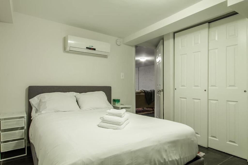 a bedroom with a white bed with towels on it at Rest Easy in this Bloomingdale English Basement in Washington, D.C.