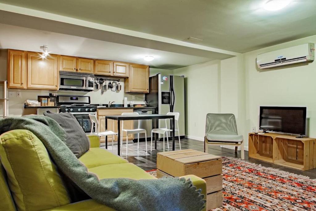 a living room with a couch and a kitchen at Rest Easy in this Bloomingdale English Basement in Washington, D.C.