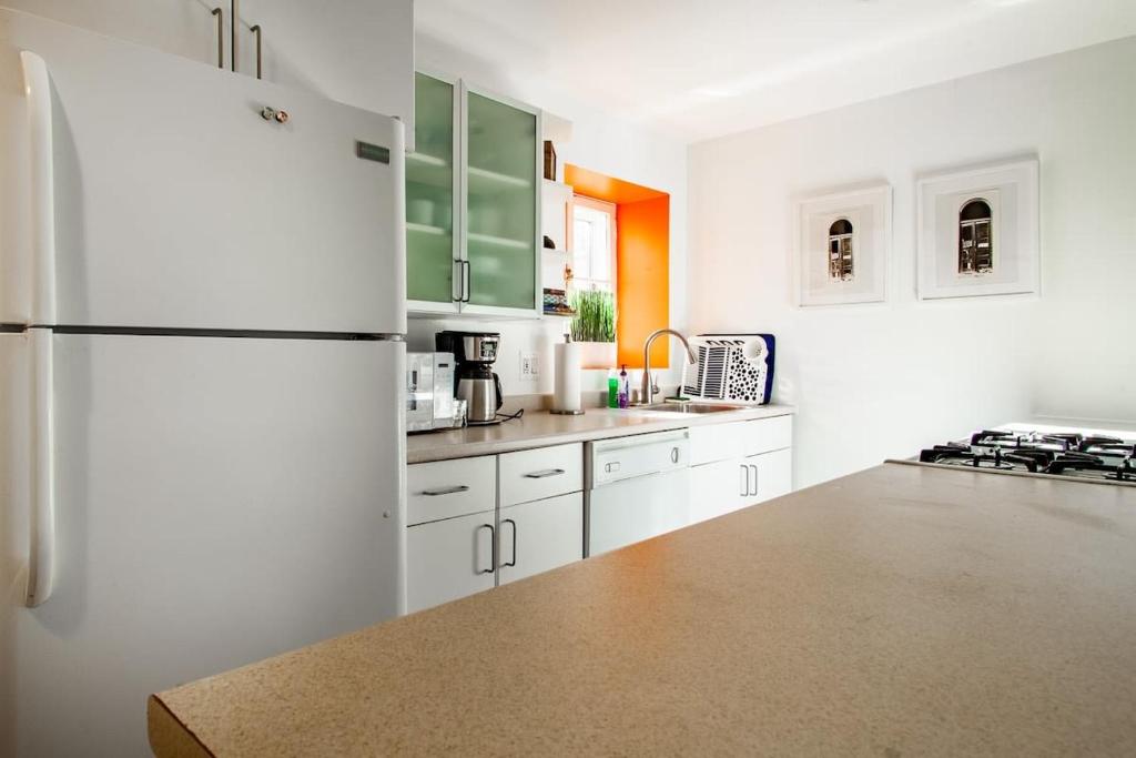 a kitchen with white cabinets and a refrigerator at Over the Moon About C Adams Morgan METRO subway Rock Creek Park in Washington, D.C.