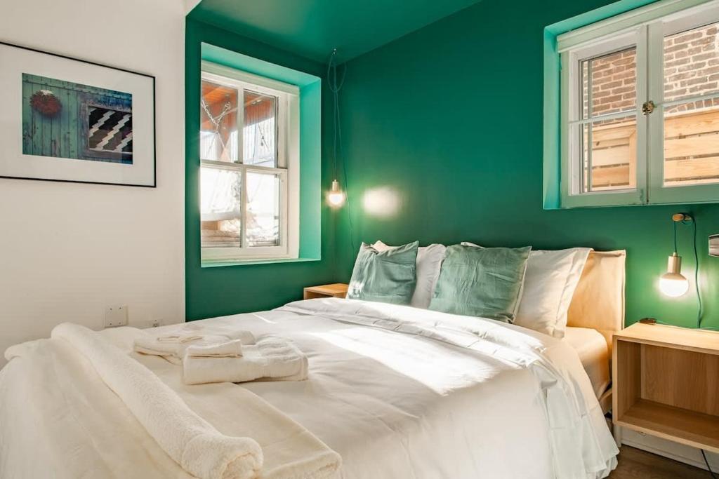 a bedroom with a large white bed with green walls at Over the Moon About C Adams Morgan METRO subway Rock Creek Park in Washington, D.C.