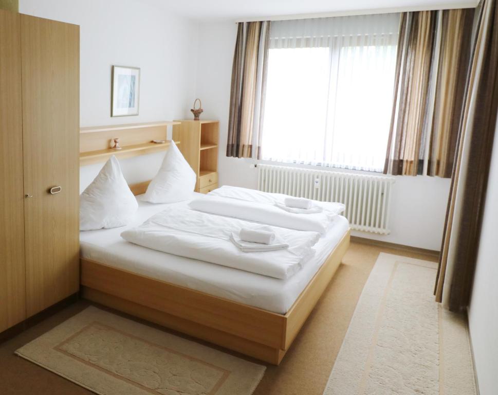 Bett in einem Zimmer mit einem großen Fenster in der Unterkunft Fewo Blumbach Nr 2, Schluchsee, Feldberg in Schluchsee