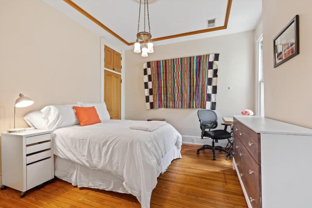 a bedroom with a bed and a desk with a chair at Capitol Hill Homestay Convenient to H St in Washington, D.C.