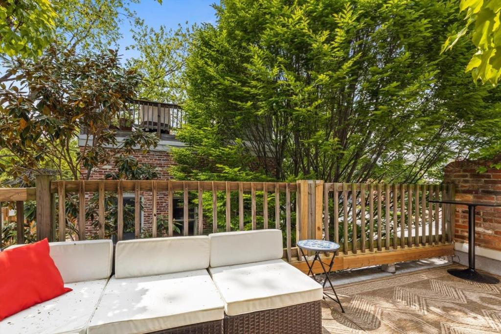 a white couch on a patio with a fence at Capitol Hill Homestay Convenient to H St in Washington, D.C.