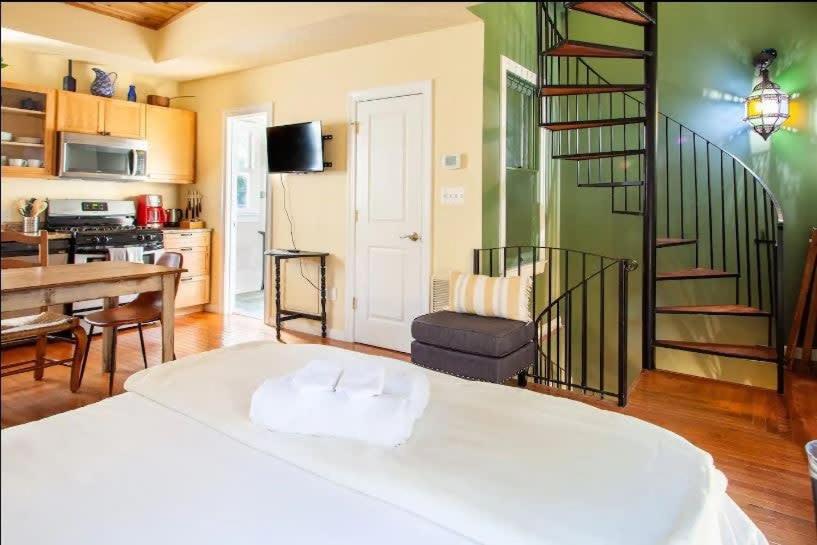 a living room with a bed and a spiral staircase at Historic Capital Hill Home and Carriage House in Washington, D.C.