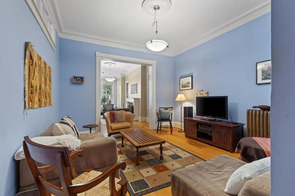 a living room with a couch and a tv at Historic Capital Hill Home and Carriage House in Washington, D.C.