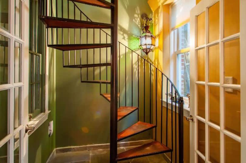 a spiral staircase in a room with green walls at Historic Capital Hill Home and Carriage House in Washington, D.C.