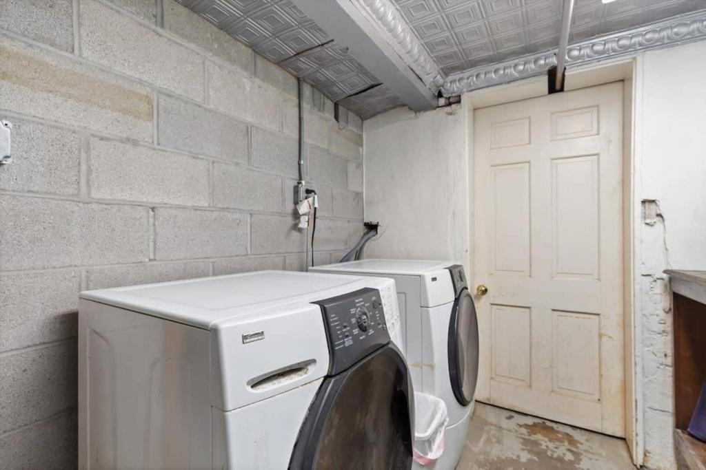 a laundry room with a washing machine and a white door at Historic Capital Hill Home and Carriage House in Washington, D.C.
