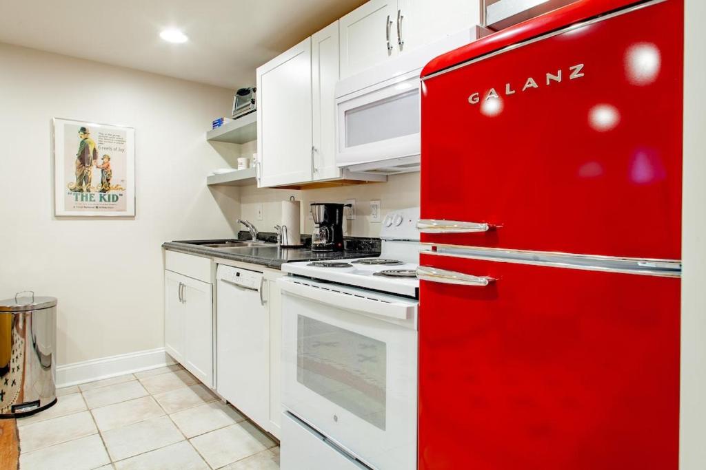 a red refrigerator in a kitchen with white cabinets at Stay Cozy in CoHi DC in Washington, D.C.