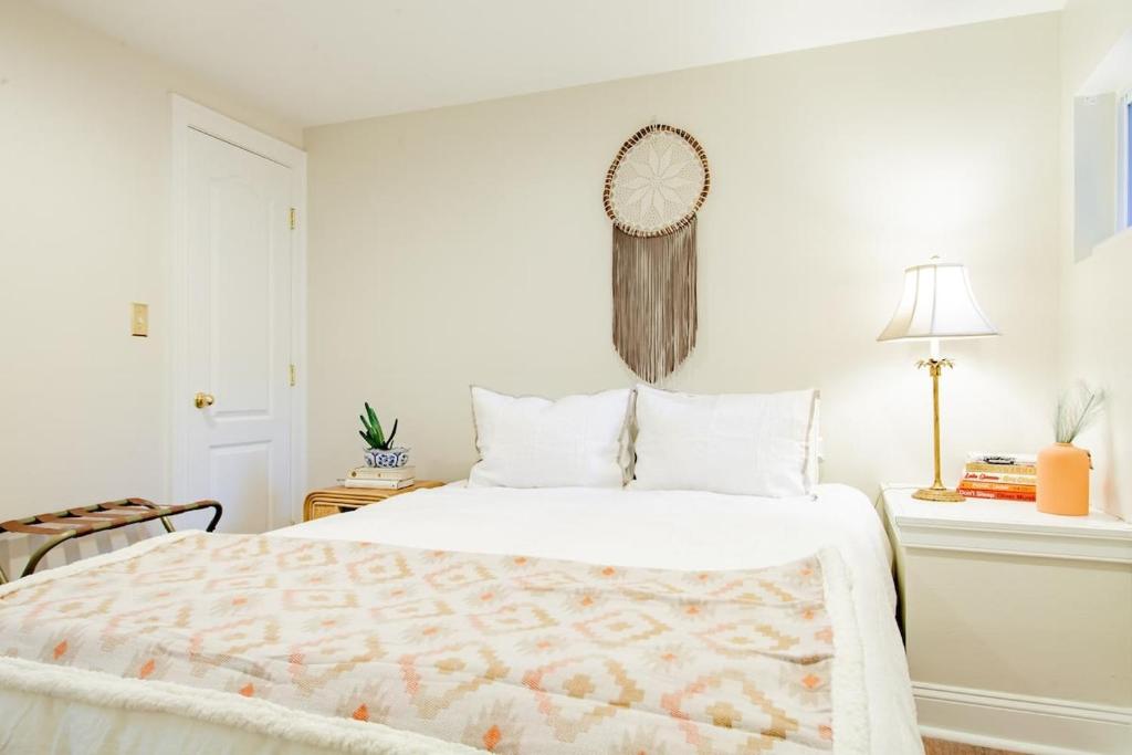 a white bedroom with a bed and a clock on the wall at Stay Cozy in CoHi DC in Washington, D.C.