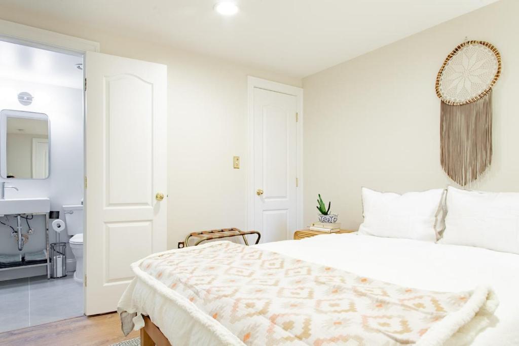 a white bedroom with a large bed and a sink at Stay Cozy in CoHi DC in Washington, D.C.
