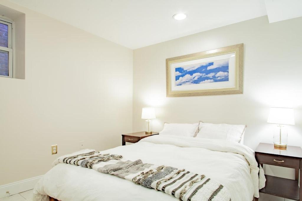 a white bedroom with two beds and two lamps at Stay Cozy in CoHi DC in Washington, D.C.
