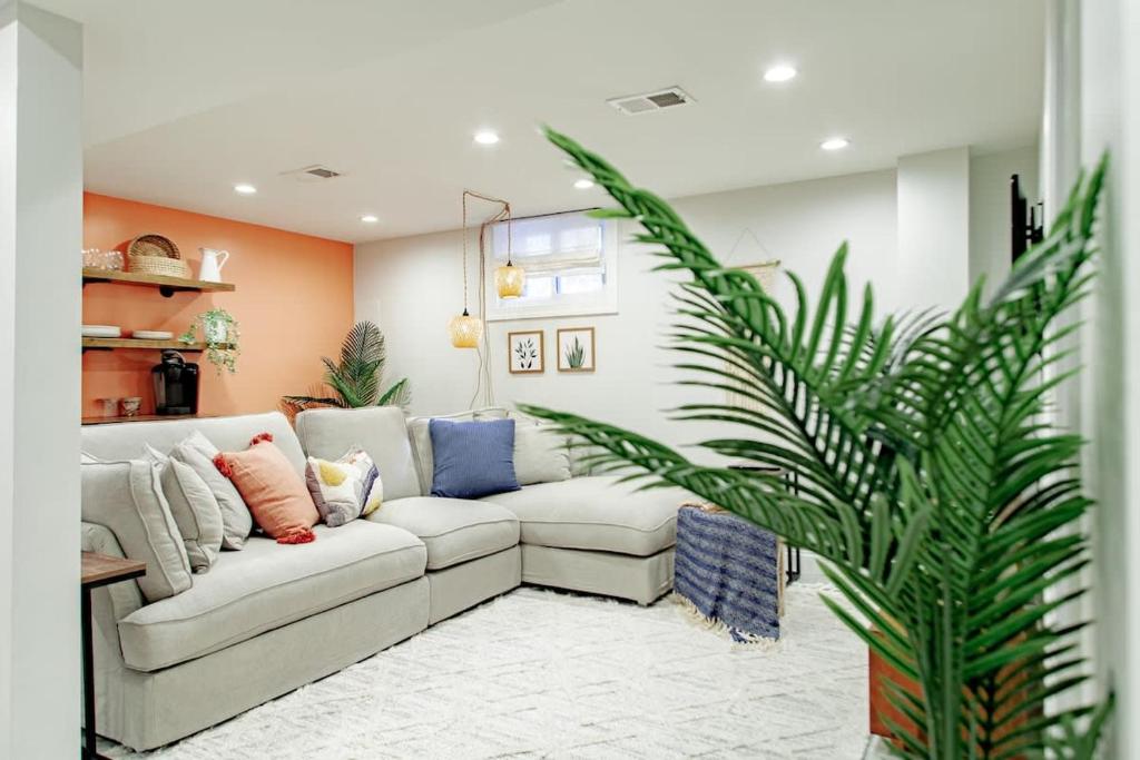 Private 1-BR DC Residential-Style Stay Parking في واشنطن: غرفة معيشة بها أريكة بيضاء وزرع