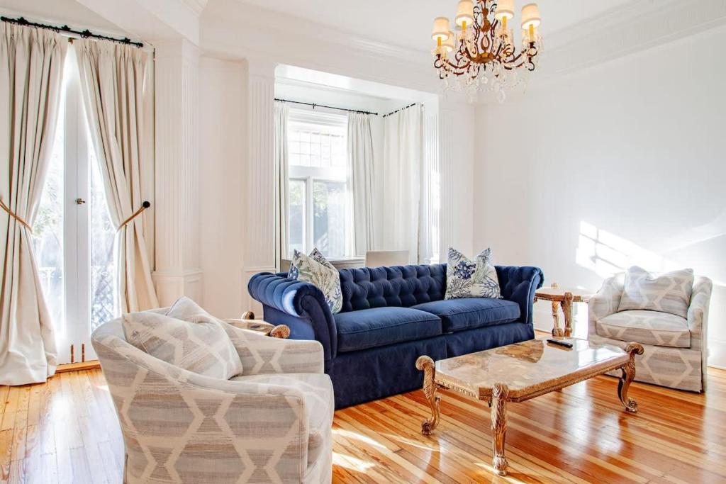 a living room with a blue couch and two chairs at LUXE Kalorama 5-BR Townhome Close to Dupont Circle in Washington, D.C.