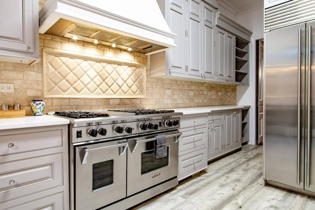 a kitchen with white cabinets and stainless steel appliances at LUXE Kalorama 5-BR Townhome Close to Dupont Circle in Washington, D.C.