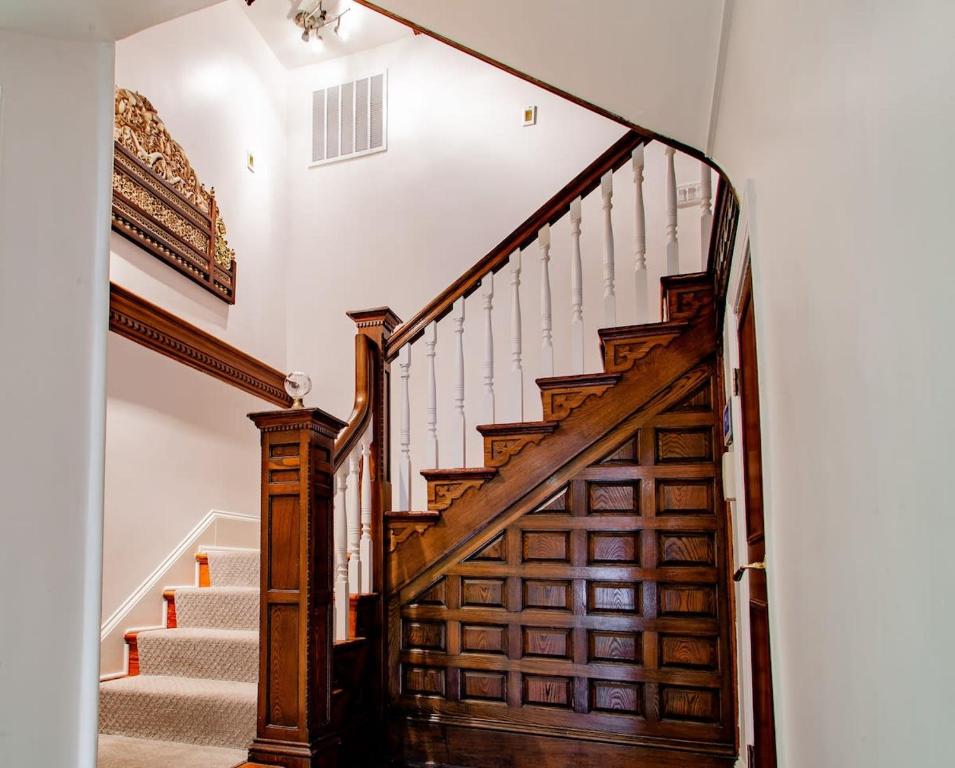a staircase with wooden railings and a wooden door at LUXE Kalorama 5-BR Townhome Close to Dupont Circle in Washington, D.C.