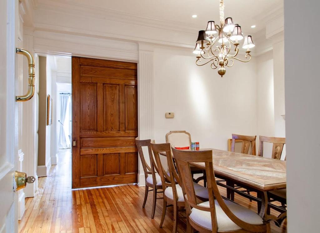 a dining room with a table and chairs and a chandelier at LUXE Kalorama 5-BR Townhome Close to Dupont Circle in Washington, D.C.