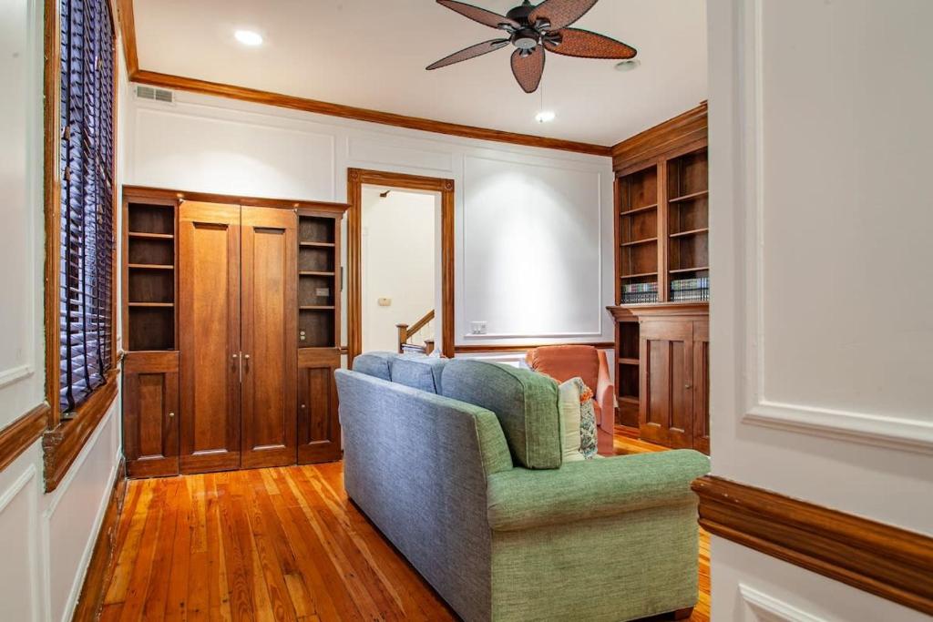 a living room with a blue couch and a ceiling fan at LUXE Kalorama 5-BR Townhome Close to Dupont Circle in Washington, D.C.