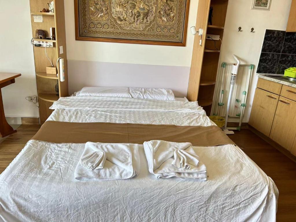 2 Betten in einem Zimmer mit weißer Bettwäsche und Handtüchern in der Unterkunft Mina view condo 12 in Pattaya South