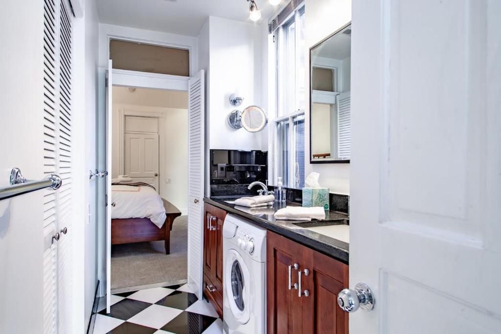 a bathroom with a sink and a washer and dryer at LUXE Kalorama 5-BR Townhome Close to Dupont Circle in Washington, D.C.