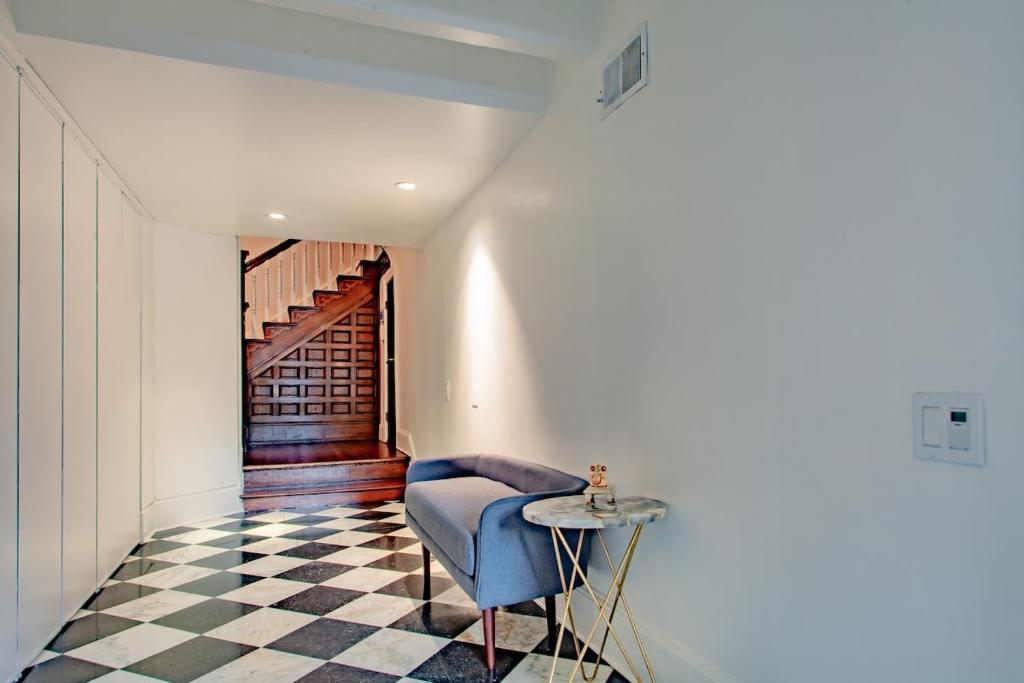 a hallway with a blue chair and a table at LUXE Kalorama 5-BR Townhome Close to Dupont Circle in Washington, D.C.