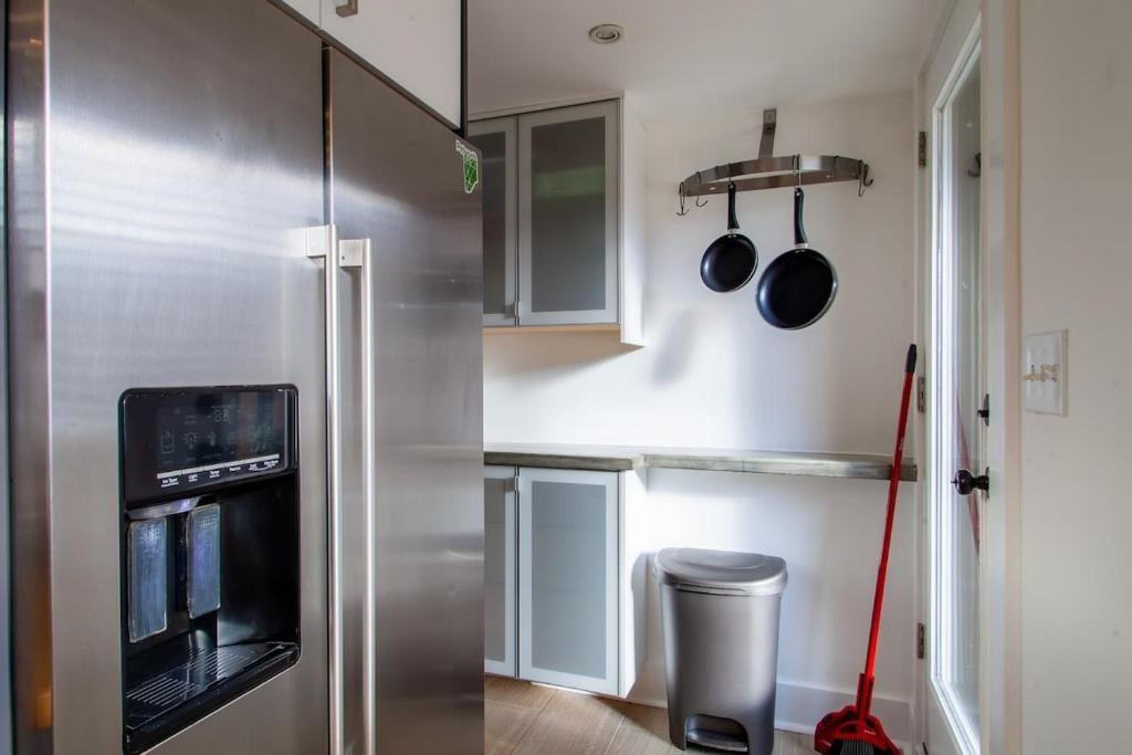a kitchen with a stainless steel refrigerator and utensils at 2-BR Petworth Pad Walk to METRO Subway in Washington, D.C.