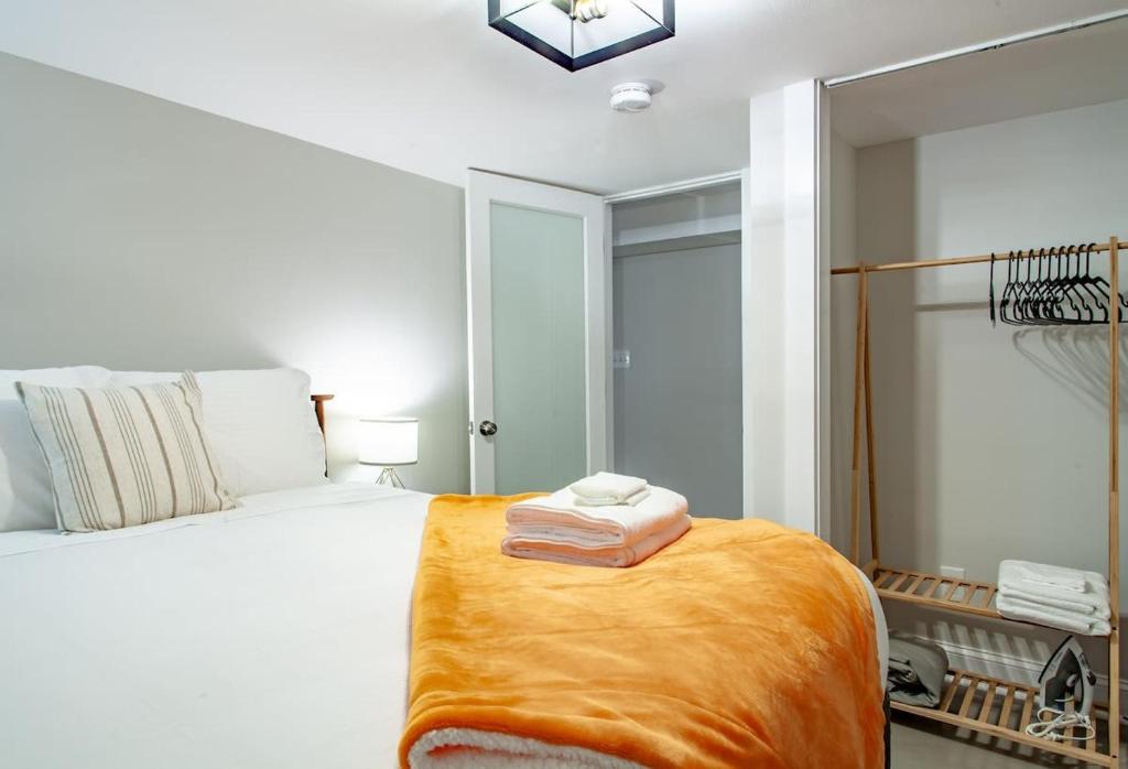 a bedroom with a bed with an orange blanket on it at 2-BR Petworth Pad Walk to METRO Subway in Washington, D.C.