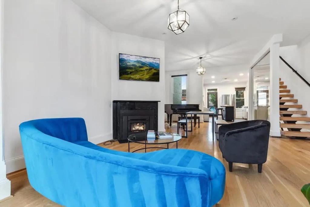 a living room with a blue couch and a fireplace at H St DC Haven 4-BR Homestay in Washington, D.C.