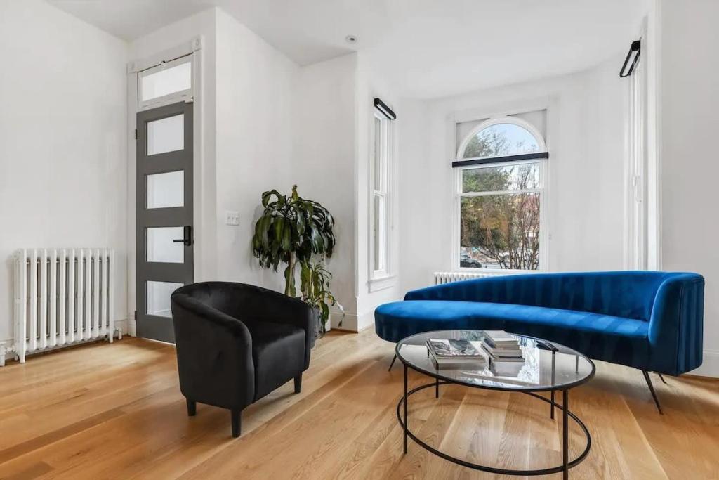 a living room with a blue couch and a table at H St DC Haven 4-BR Homestay in Washington, D.C.