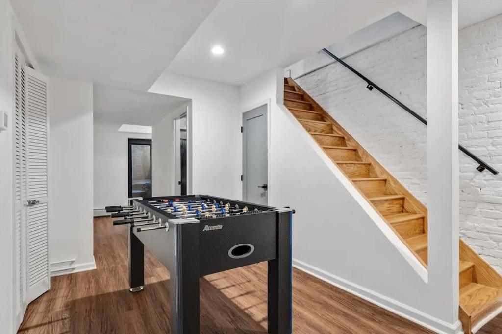 a ping pong table in a room with stairs at H St DC Haven 4-BR Homestay in Washington, D.C.
