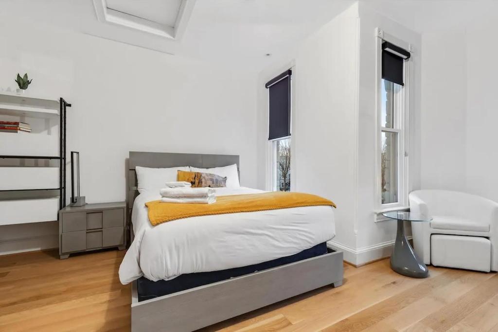 a bedroom with a large bed with white walls at H St DC Haven 4-BR Homestay in Washington, D.C.