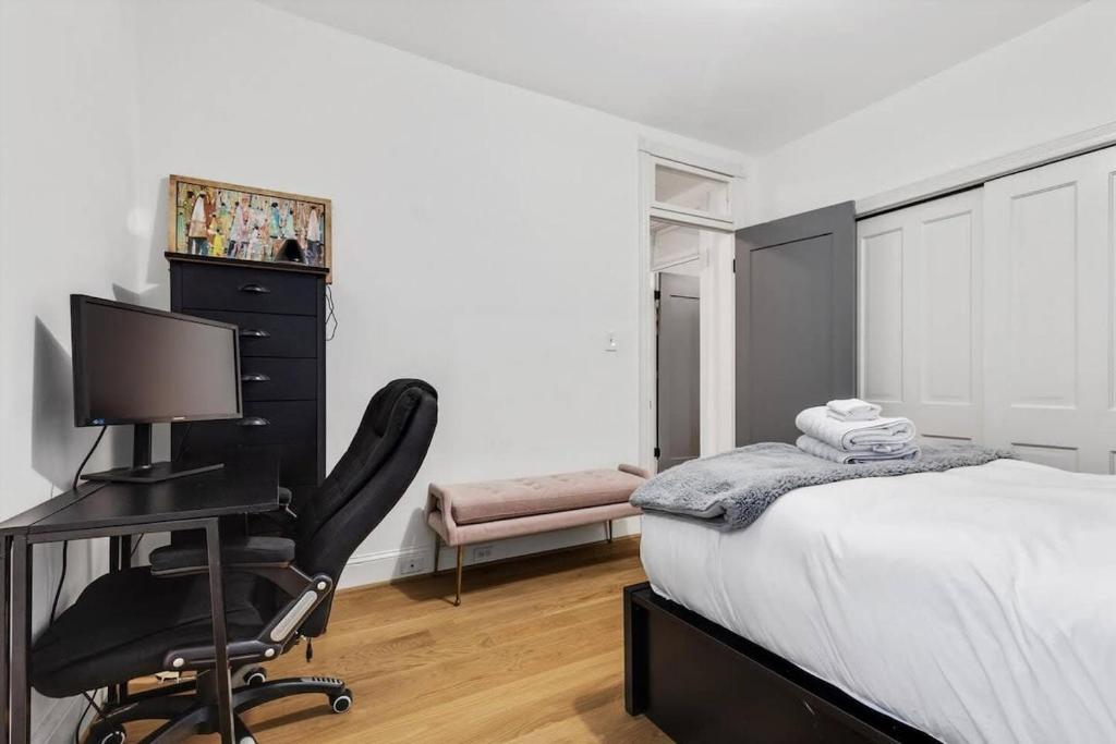 a bedroom with a bed and a desk with a computer at H St DC Haven 4-BR Homestay in Washington, D.C.