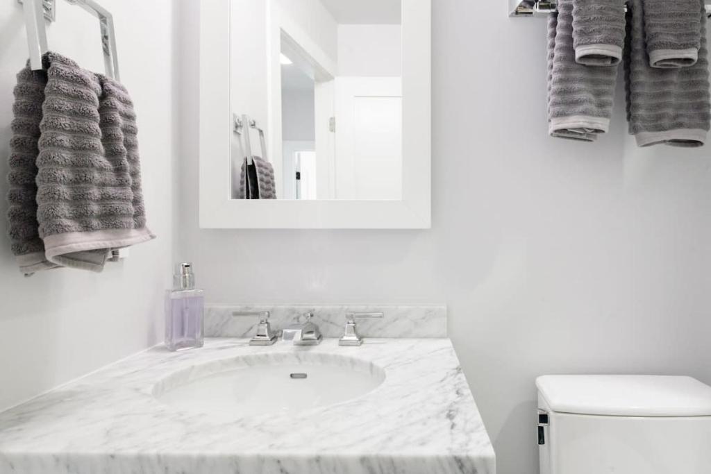 a white bathroom with a sink and a mirror at Historic Charming Home in Old Town in Alexandria
