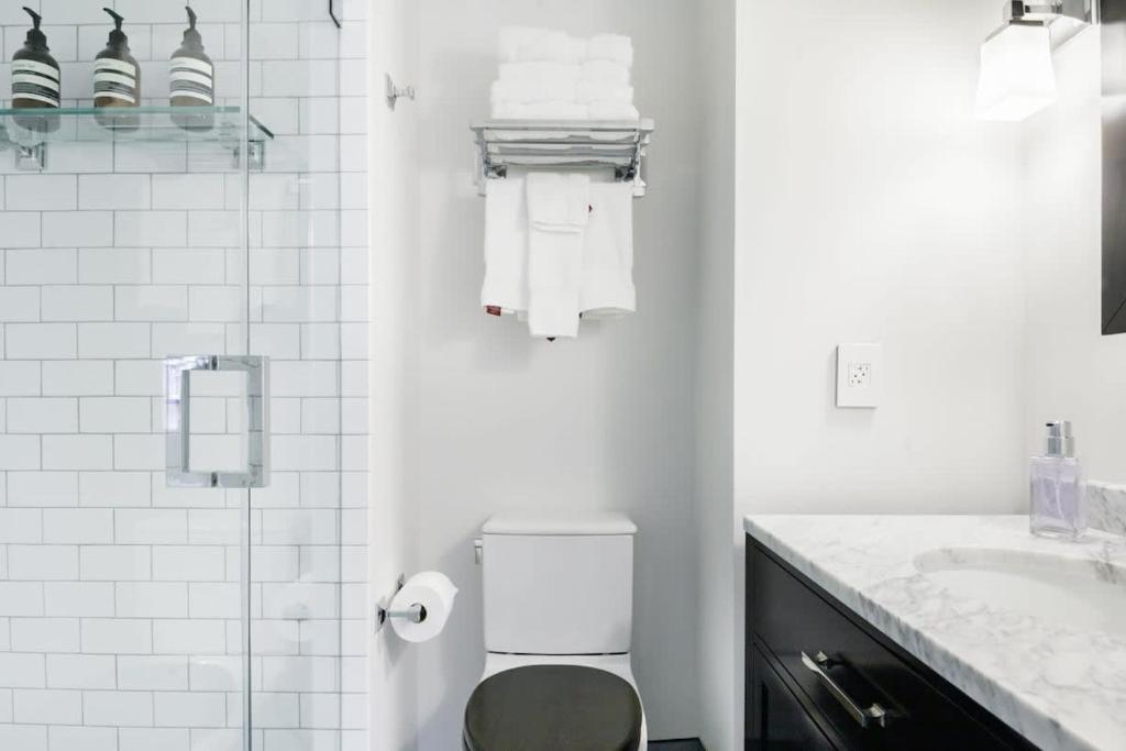 a white bathroom with a toilet and a sink at Historic Charming Home in Old Town in Alexandria