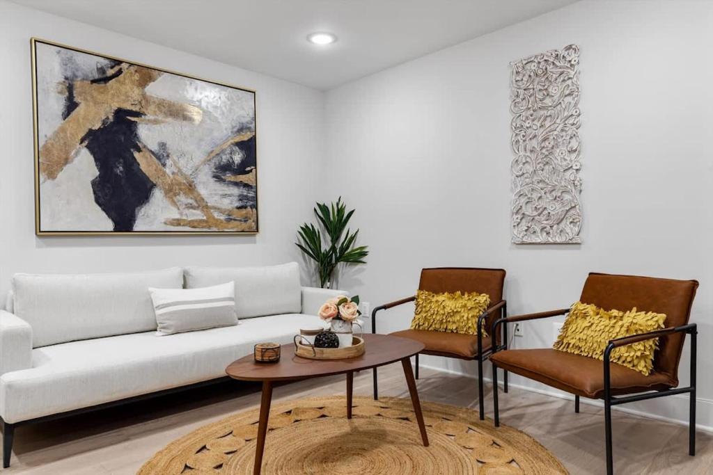 a living room with a white couch and two chairs at Excellent 2-BR Condo in Hip Area of DC in Washington, D.C.